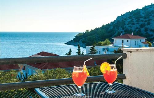 two cocktails on a table on a balcony overlooking the ocean at Seahorse Apartments in Ražanj