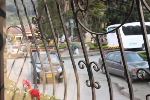 a wrought iron fence with cars on a city street at Hotel El Parque HR in Fómeque