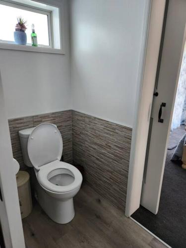 a bathroom with a toilet and a window at #40 Below in Waitarere