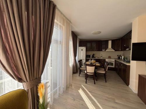 a kitchen and dining room with a table and a window at GRAND APARTMENT BOGORIDI - top center near to sea and sea garden in Burgas City