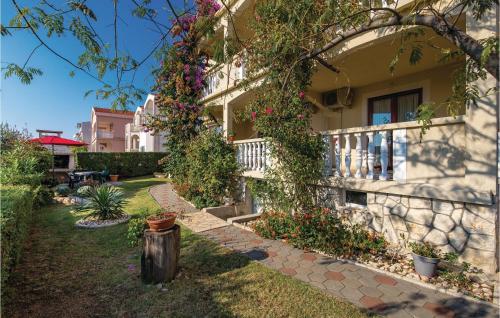 a house with flowers on the side of it at Nice Apartment In Povljana With Wifi in Povljana