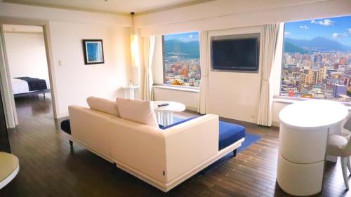 a living room with a couch and a large window at Premier Hotel Nakajima Park Sapporo in Sapporo