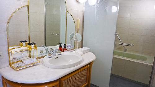 a bathroom with a sink and a shower at Premier Hotel Nakajima Park Sapporo in Sapporo