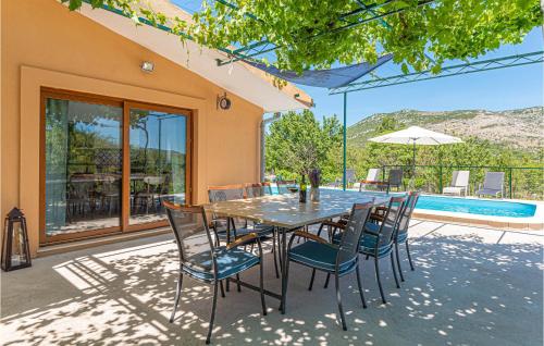 a dining room table with chairs and a pool at Holiday Home Mravnica 09 in Mravnica