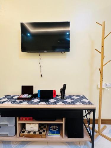 a table with a tv hanging on a wall at Rivero Transient House in San Fernando