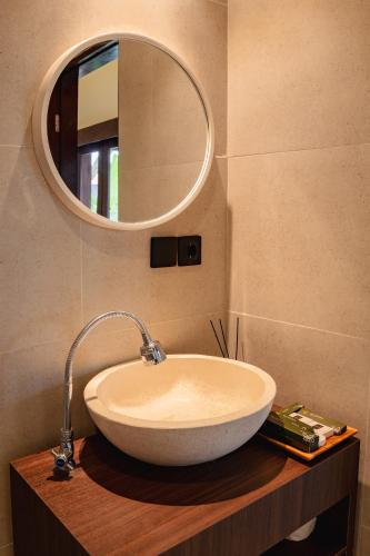 a bathroom with a sink and a mirror at Tut Winten a Tranquil Living Villa Ubud in Ubud
