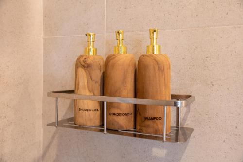 four bottles sitting on a shelf in a bathroom at Tut Winten a Tranquil Living Villa Ubud in Ubud