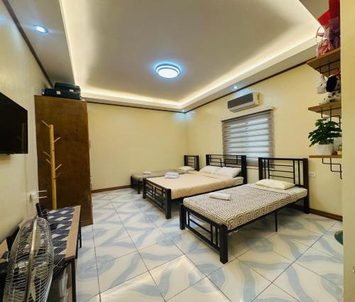 a room with two beds and a tv in it at Rivero Transient House in San Fernando