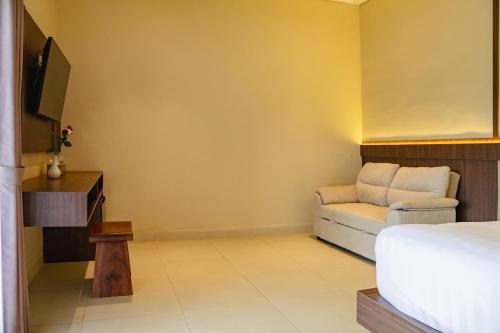 a room with a bed and a couch and a tv at Tut Winten a Tranquil Living Villa Ubud in Ubud