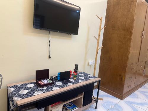 a room with a table with a television on a wall at Rivero Transient House in San Fernando