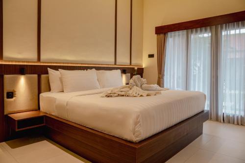 a bedroom with a large bed with a large window at Tut Winten a Tranquil Living Villa Ubud in Ubud