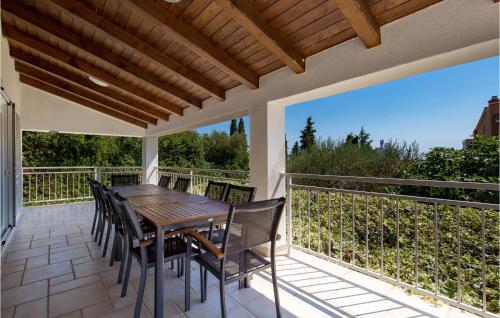a patio with a wooden table and chairs on a balcony at 3 Bedroom Cozy Home In Krk in Krk