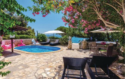 un patio con tavolo, sedie e piscina. di Amazing Home In Kozino With Sauna a Kožino