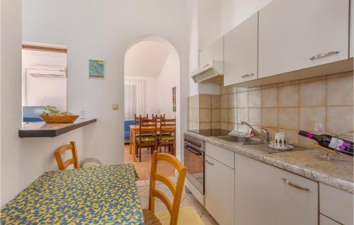 a kitchen and dining room with a table and a dining room at Lovely Apartment In Njivice in Njivice