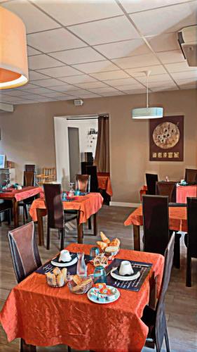 a dining room with orange tables and chairs at HOTEL LES MARRONNIERS in Thueyts