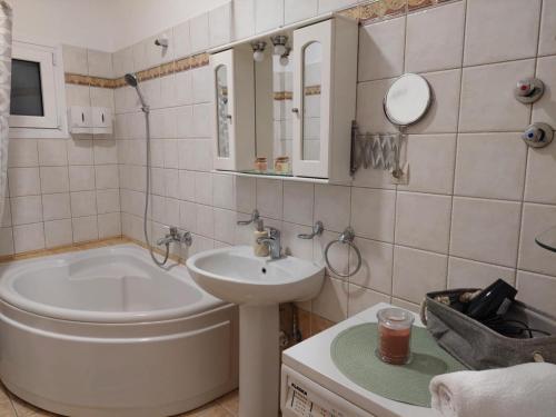 a bathroom with a sink and a toilet and a tub at Ourania's Apartment Kastoria in Mavrokhórion