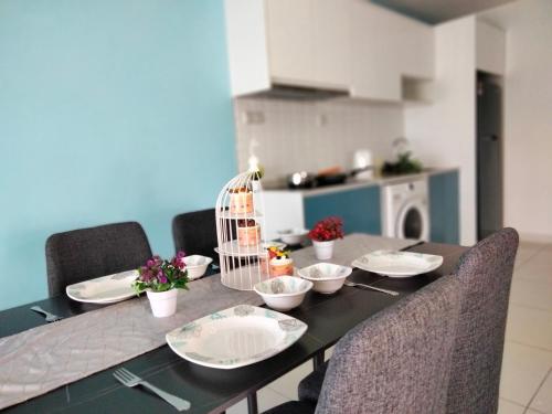 a dining room table with plates and bowls on it at Continew Residence by HomeBrickz in Kuala Lumpur