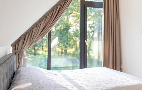 a bedroom with a bed and a large window at Cozy Home In Czarnocin With Lake View in Czarnocin