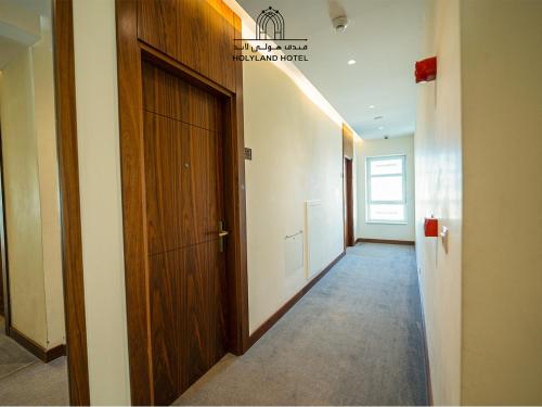 a hallway with a wooden door in a room at Holyland Hotel Amman in Amman