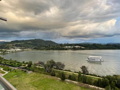 a boat on a large lake on a cloudy day at Náutica Lake Paipa - Penthouse in Paipa