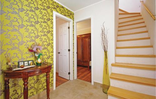 a hallway with yellow wallpaper and a wooden table at Holiday Home Gornji Tucepi-Srida Sela Bb Ii in Tučepi