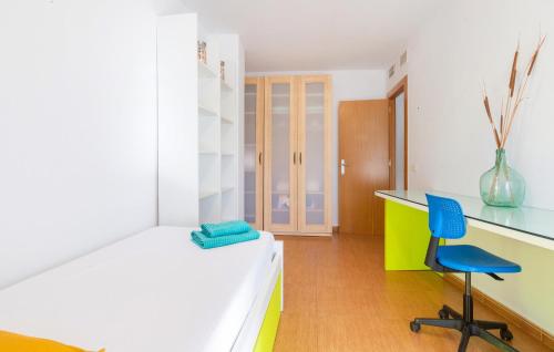 a bedroom with a desk and a blue chair at Amazing Apartment In Lorca With Wifi in Lorca