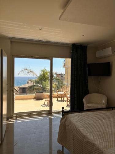 a bedroom with a bed and a view of the ocean at IG - "Villa Don Antonio" Apartments in Giardini Naxos