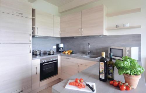 a kitchen with white cabinets and a counter with fruits and vegetables at Nice Home In Dagebüll With Sauna in Dagebüll