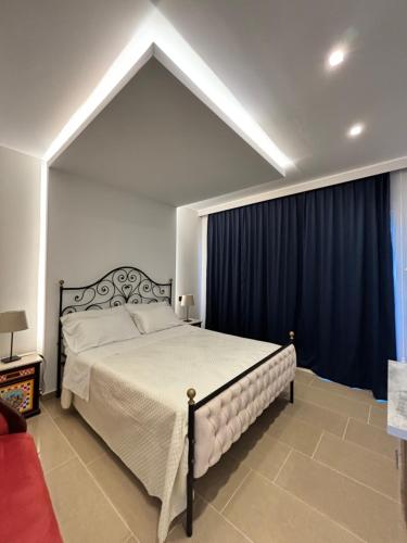 a bedroom with a large bed with blue curtains at IG - "Villa Don Antonio" Apartments in Giardini Naxos