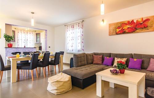 a living room with a couch and a dining room at Nice Home In Hr-52215 Vodnjan in Vodnjan