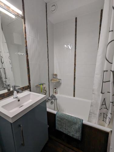 La salle de bains est pourvue d'un lavabo et d'une baignoire avec lavabo. dans l'établissement La Foux d'Allos Duplex au pied des pistes, à La Foux d'Allos