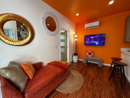 a living room with a couch and a mirror at Resort Getaway in Private Garden Terrace Villa w Luxury Amenities in Los Angeles