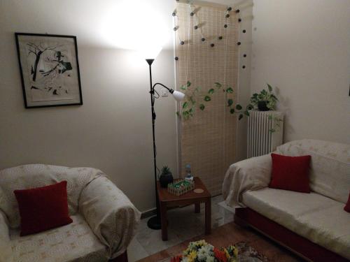 ein Wohnzimmer mit 2 Sofas und einer Lampe in der Unterkunft Cozy & Bright Home - 50m from metro station Άg Antonios in Athen