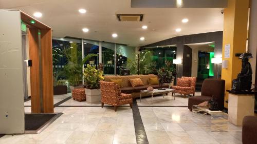 a lobby with a couch and chairs in a building at Holiday Inn Cuernavaca by IHG in Cuernavaca