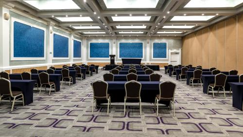 a conference room with tables and chairs and windows at Holiday Inn Cuernavaca by IHG in Cuernavaca