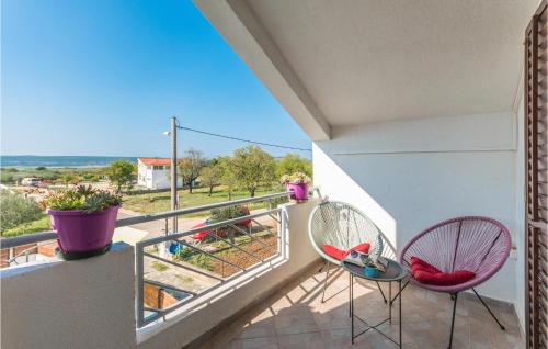 a balcony with two chairs and a view at Pet Friendly Home In Tinj With Jacuzzi in Tinj