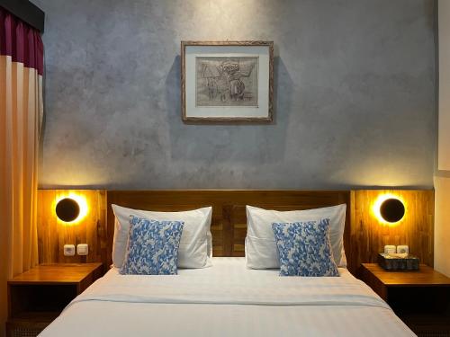 sypialnia z łóżkiem z niebieskimi i białymi poduszkami w obiekcie Kubu Indah Homestay Sanur w mieście Sanur