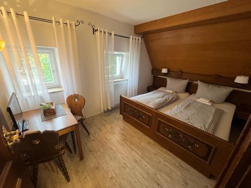 a bedroom with a large wooden bed and a desk at Gästehaus Goldenes Lamm in Rothenburg ob der Tauber