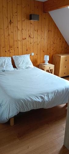 a large bed in a room with wooden walls at LUZVAL Duplex avec Balcon in Luz-Saint-Sauveur