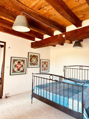 une chambre avec un lit dans une pièce avec des plafonds en bois dans l'établissement Maison de charme à 1h30 de Paris, à Nargis