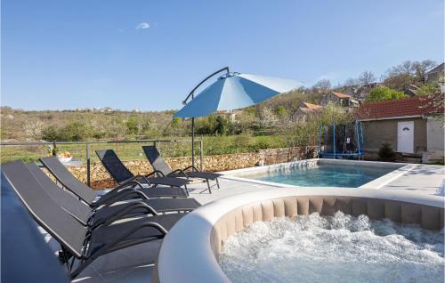 a swimming pool with chairs and an umbrella at Lovely Home In Ramljane in Ramljane