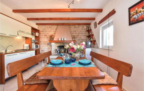 une salle à manger avec une table en bois et une cuisine dans l'établissement Pet Friendly Home In Postira With Wifi, à Postira