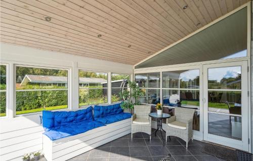 a screened in porch with a blue couch and a table at Holiday Home Børkop With Hot Tub Xiv in Børkop