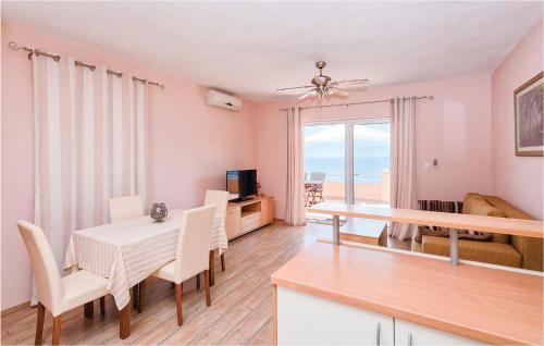 a dining room with a table and chairs and a view of the ocean at Holiday Home Zastrazisce With Sea View 04 in Selca kod Bogomolja