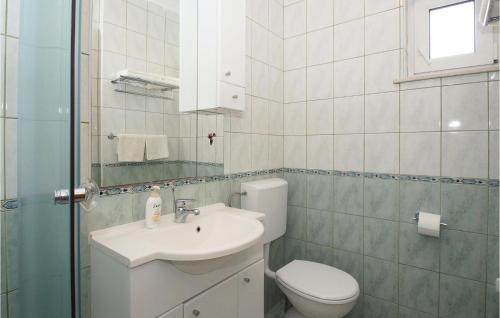a white bathroom with a toilet and a sink at Holiday Home Zastrazisce With Sea View 04 in Selca kod Bogomolja