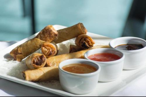 a plate of food with dipping sauces on a table at Envoy Continental Hotel, Islamabad in Islamabad