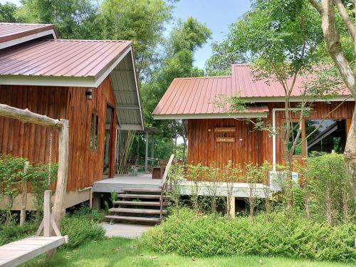 a wooden house with a staircase leading to it at Teak@Teak in Ban Cha-om