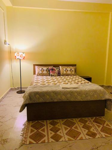 a bedroom with a bed with a yellow wall at Windchime9 in Guwahati