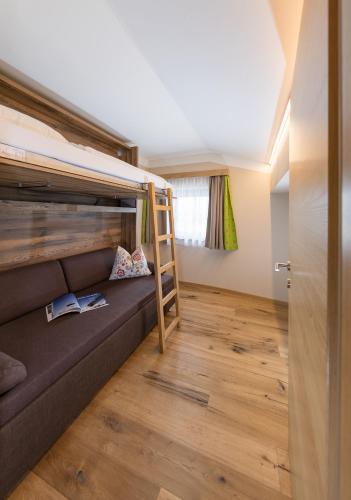a room with a bunk bed and a ladder at Hotel zum Hirschen Zell am See in Zell am See