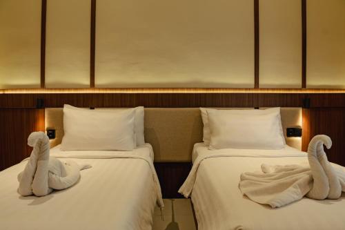 two swans sitting on two beds in a hotel room at Tut Winten a Tranquil Living Villa Ubud in Ubud